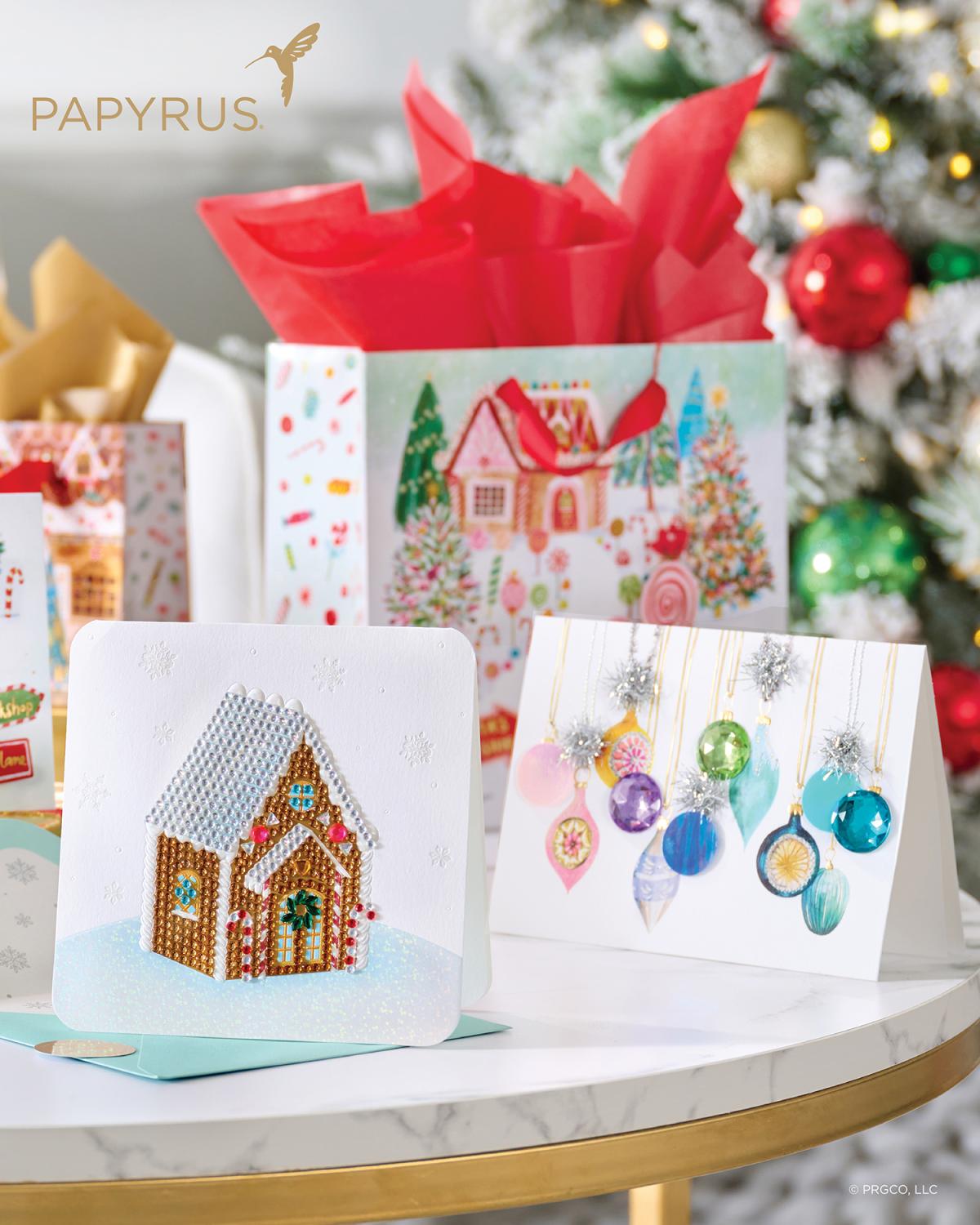 Papyrus logo with Christmas cards and gift bags in front of a Christmas tree