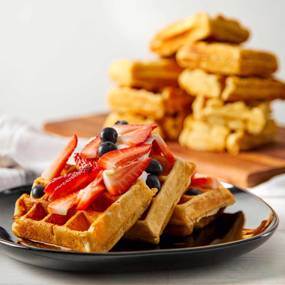 waffles and berries on a plate with whip cream