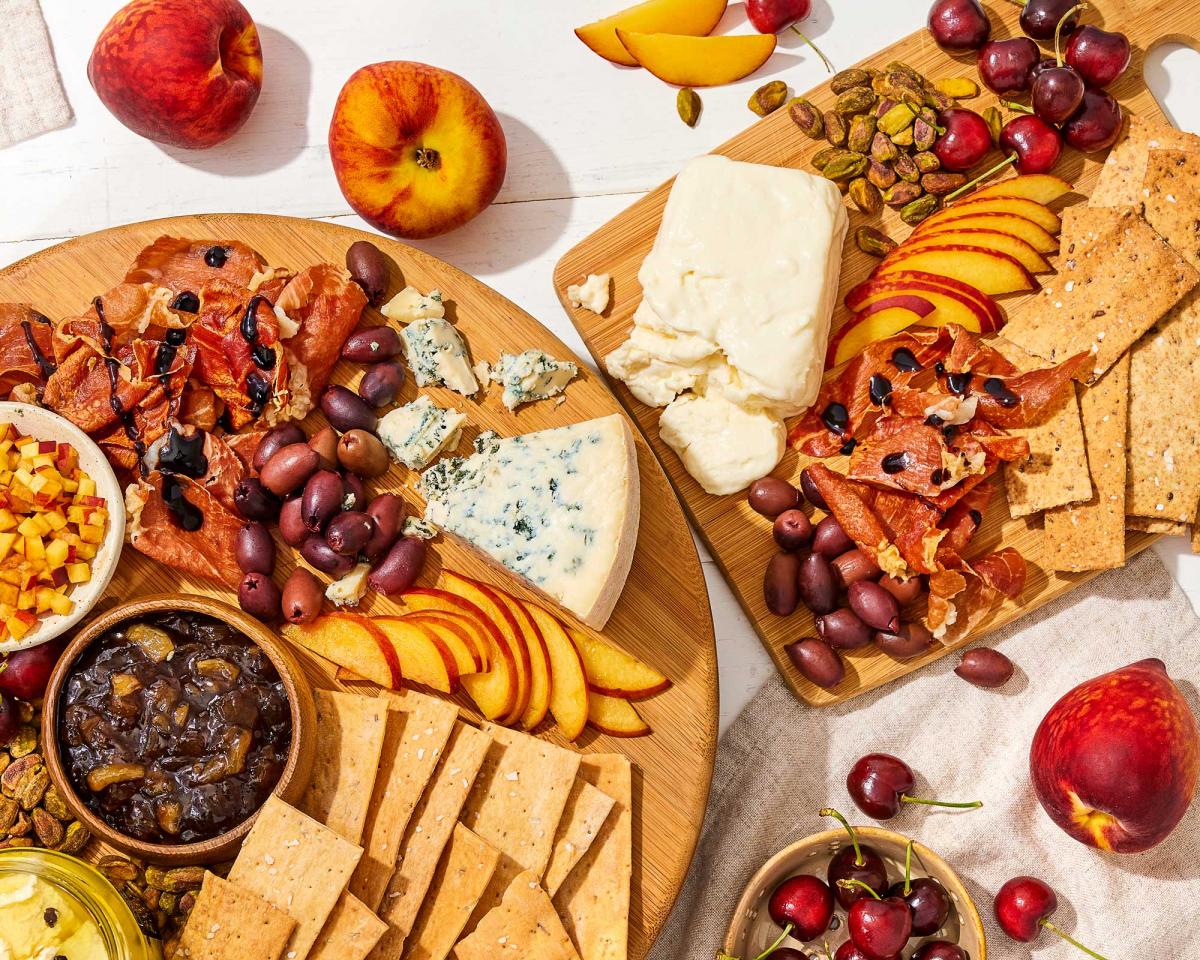 Stone Fruit and Cheese charcuterie board with dellalo olivesd, Pistachios No Shell, crackers, Stonewall Roasted Garlic Onion Jam, Meredith Dairy sheep and goat cheese, belgioioso crescenza stracchino and bay blue point reyes blue cheese, peaches, cherries