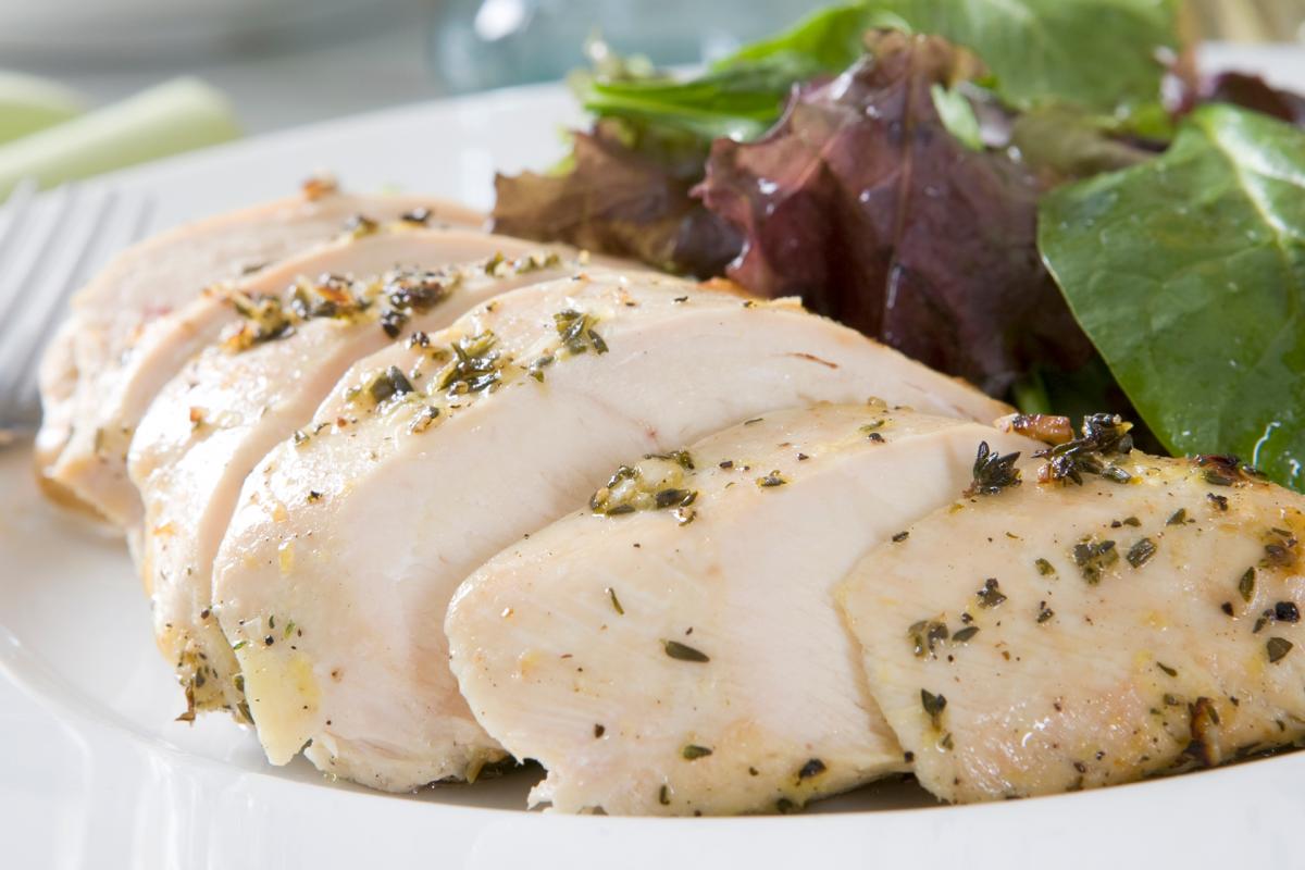 sliced chicken breast on a plate with greens