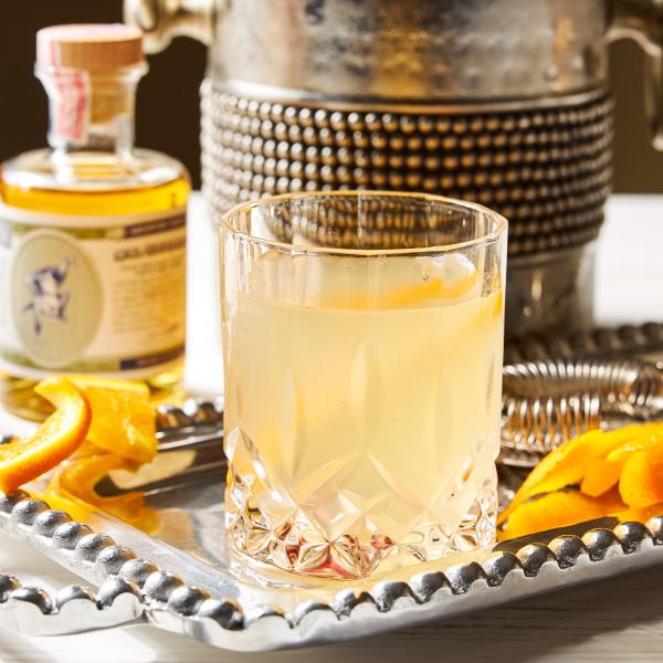 corpse reviver cocktail on a tray with orange pieces