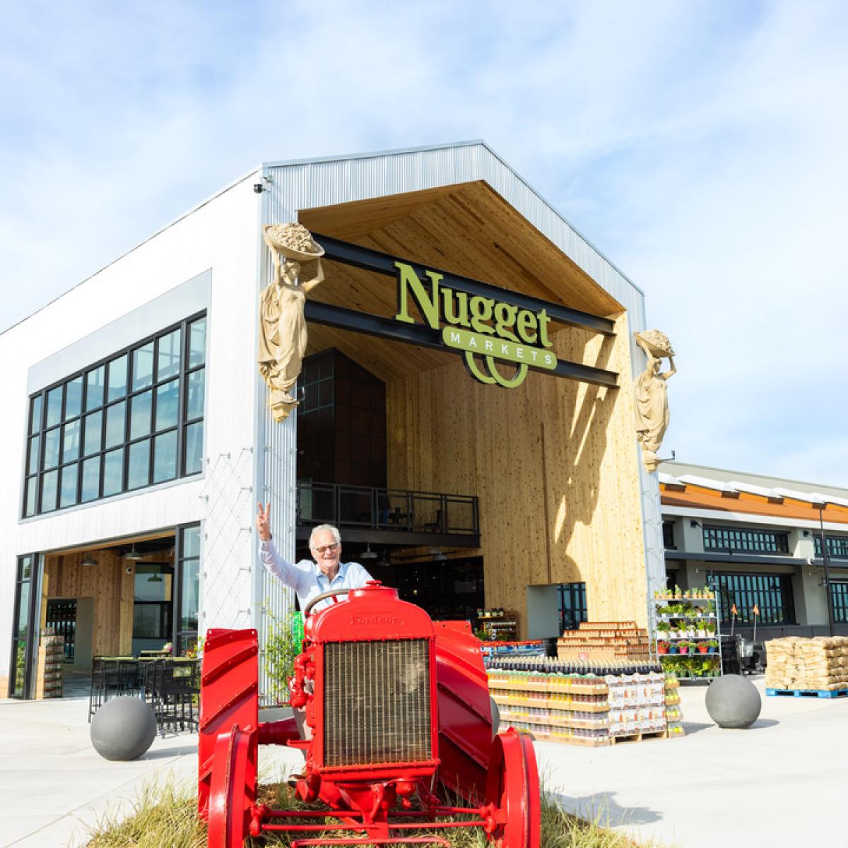Chairman of the Board and fourth generation grocer Eric Stille sitting in a red tractor outside the Rocklin Nugget Market store
