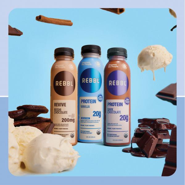 Three bottles of REBBL protein drinks with ice cream, chocolate, and cinnamon sticks floating around them