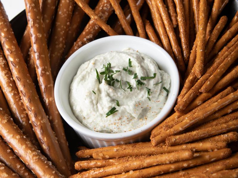 four cheese artichoke dip surrounded by pretzels