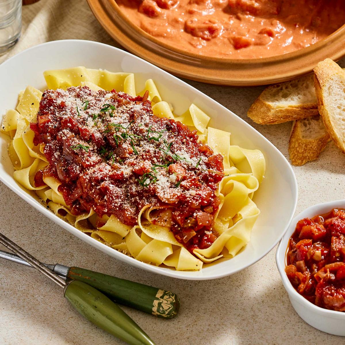 Marinara Sauce on a bed of pasta with a small bowl of it on the side
