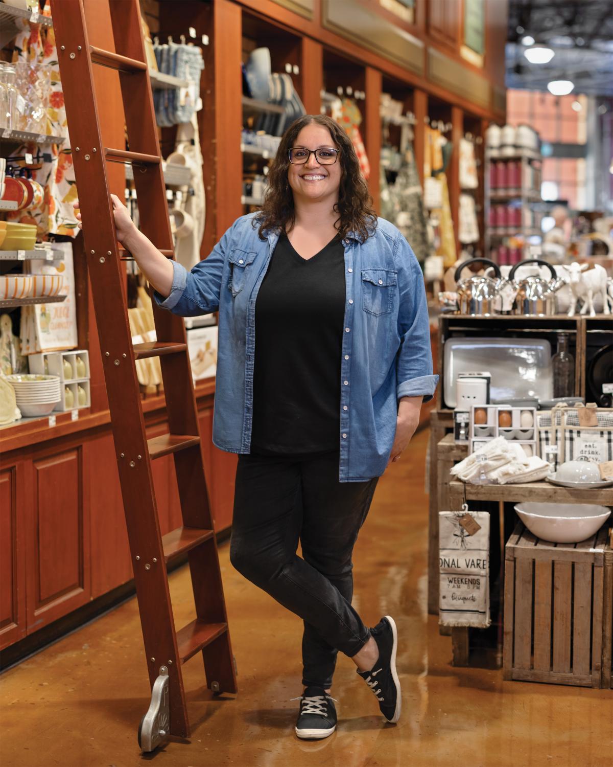 Woman standing next to ladder in general merchandise department of Nugget Market