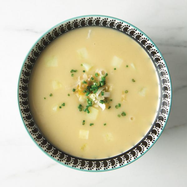 Bird's eye view of bowl of potato leek soup with minced chives on top