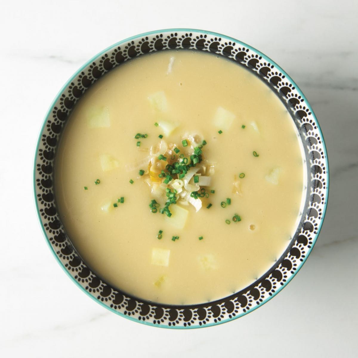 Bird's eye view of bowl of potato leek soup with minced chives on top