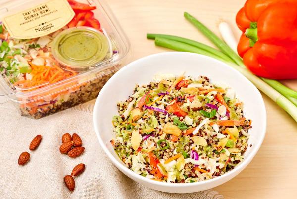 Thai Sesame Quinoa Bowl plated and in clear package with almonds, green onions, and a red pepper on the side