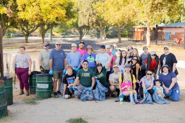 A group of Nugget Market associates at the American River holding trash bags