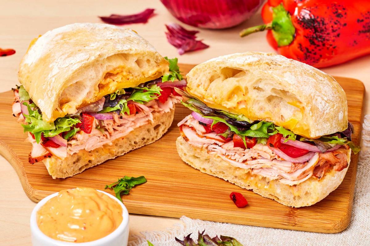 Firecracker sandwich cut in half on wooden board