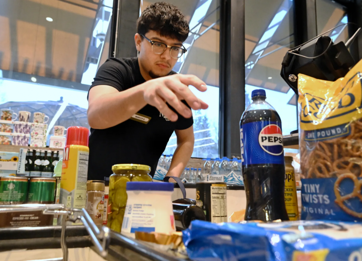 Young man reaching for grocery products while practicing for a bagging competition