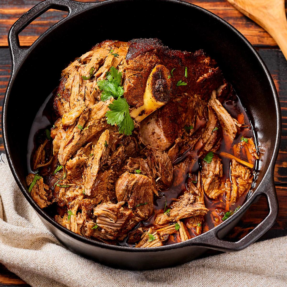 Slow-Cooker-Pork-Picnic Shoulder flaking off the roast in a cast iron pot