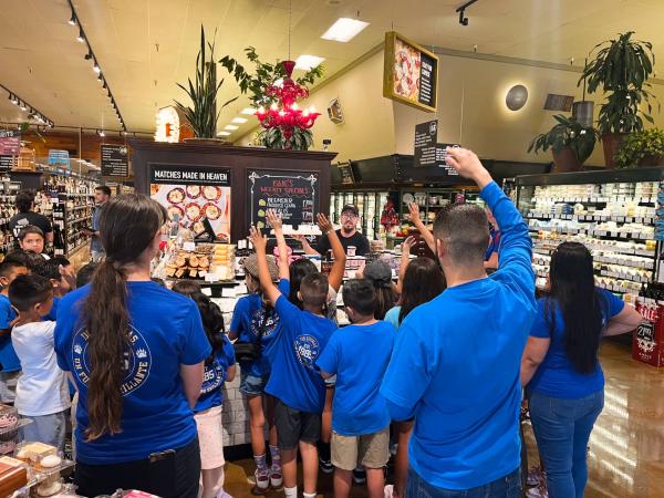 An elementary school class at the cheese counter during a store tour of Nugget Market Woodland.