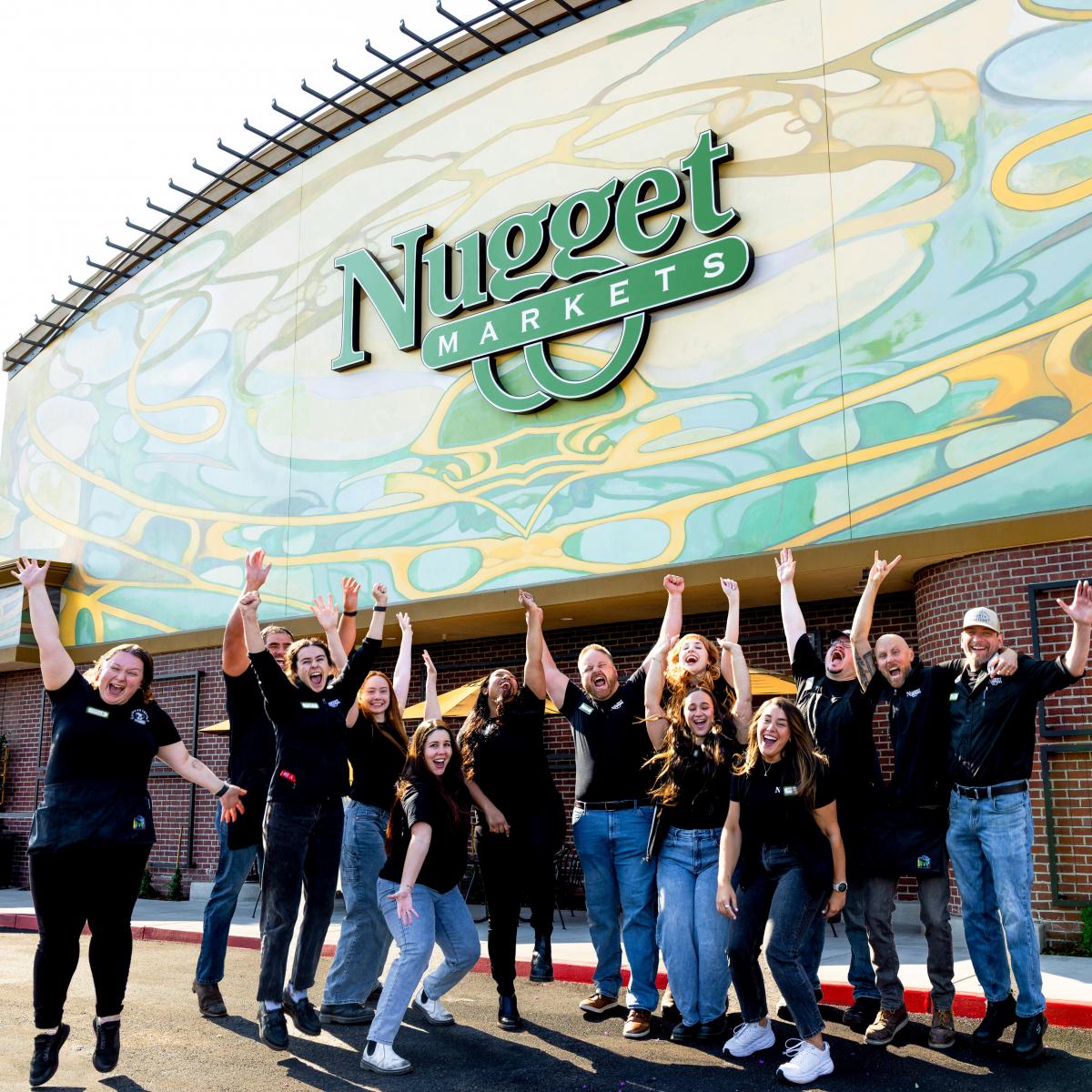 Group of excited associates outside Nugget Market Granite Bay store