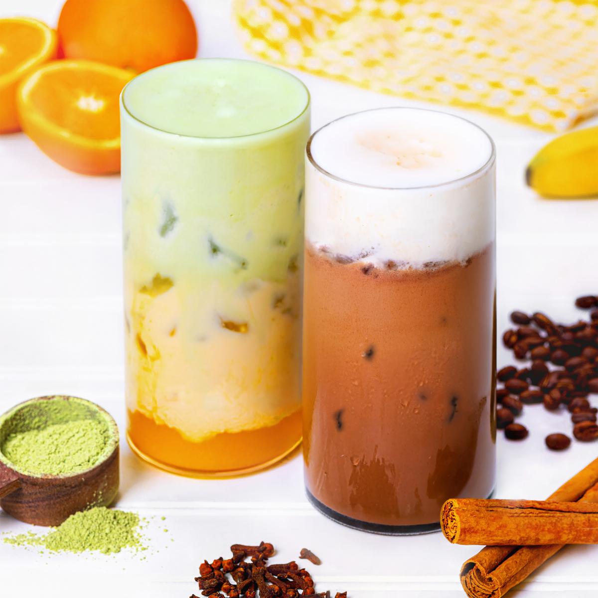 Iced Matcha Sunrise and Iced Mocha Nana Coffee Bar drinks with green tea, coffee beans, cinnamon sticks, oranges, cloves, a banana, and a cloth napkin