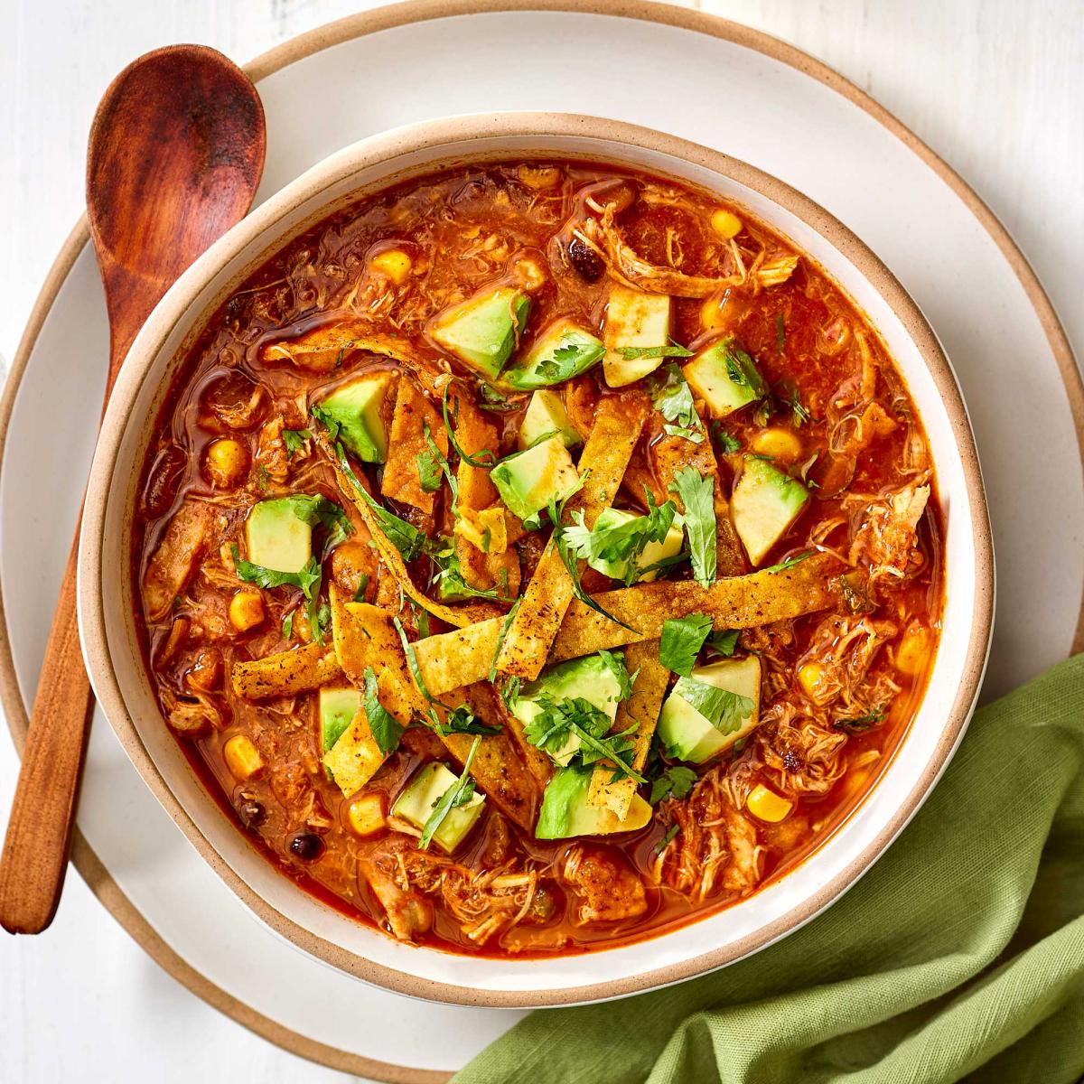 Tortilla Soup with tortilla strips, chopped avocado and cilantro on top