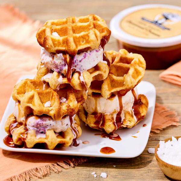 Three waffle ice cream sandwiches on a plate with Fresh to Market Caramel in the background